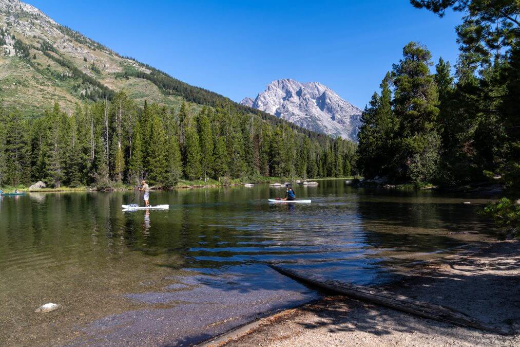  Kayakers and paddleboarders boating on String Lake, in Grand Teton National Park